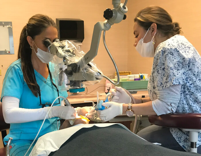 A dental staff woman working with a patient with dental equipment